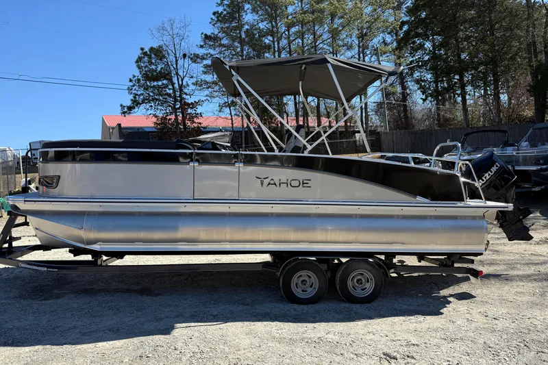 Slide: The Image of 2026 Tahoe Pontoon Cascade Versatile Rear Bench 23 on trailer, outdoor setting. - 1