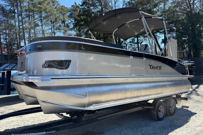 Slide: The Image of 2026 Tahoe Pontoon Cascade Versatile Rear Bench 23 on trailer, parked outdoors. - 2