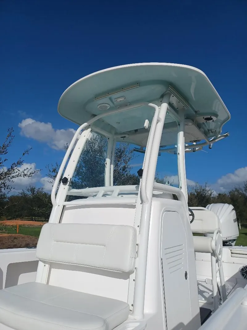 Slide: The Image of 2022 Everglades 243 Center Console boat with T-top against clear blue sky. - 11