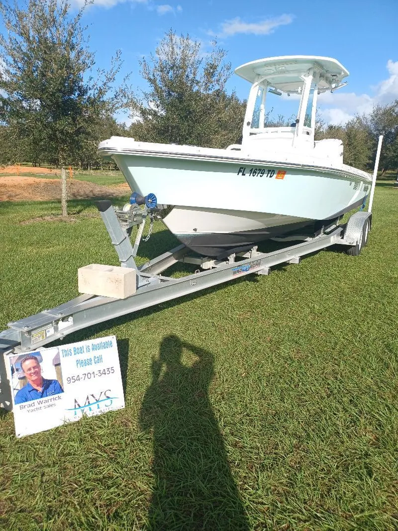 Slide: The Image of 2022 Everglades 243 Center Console boat on trailer, displayed outdoors with promotional sign. - 5