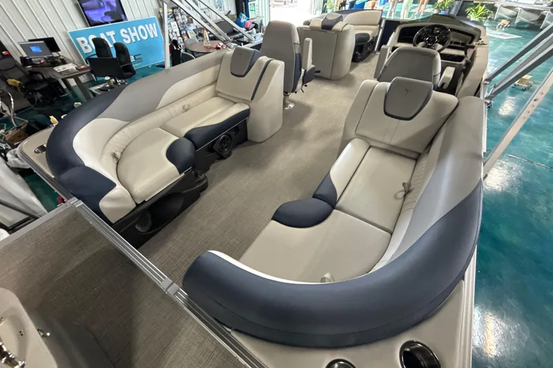 Slide: The Image of 2026 Tahoe Pontoon LTZ Quad Lounger interior with luxurious seating at a boat show. - 5
