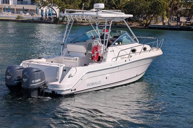 The Image of 2014 Robalo R305 Walkaround boat with dual Yamaha engines on water. - 0