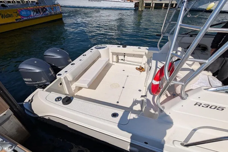 Slide: The Image of 2014 Robalo R305 Walkaround boat with Yamaha engines docked at marina. - 14
