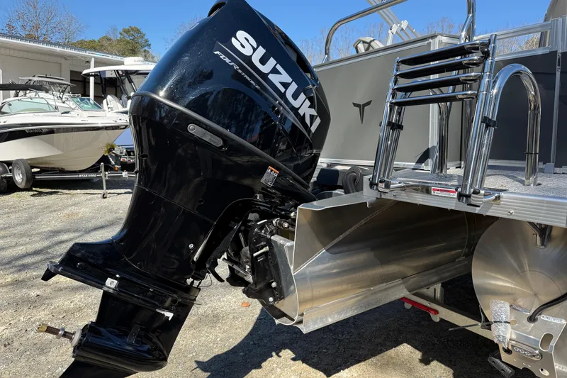 Slide: The Image of 2026 Tahoe Pontoon Sport 85 Rear Fish with Suzuki outboard motor, parked outdoors. - 9