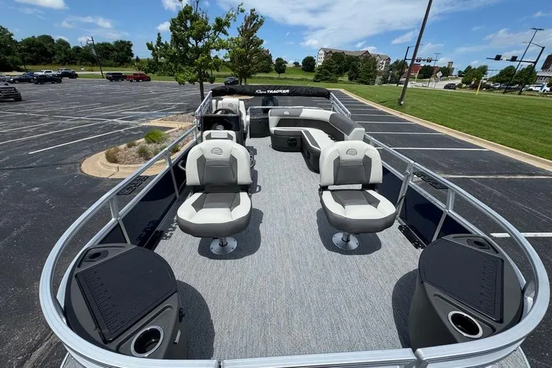 Slide: The Image of 2026 Sun Tracker Bass Buggy 18 DLX pontoon boat with spacious seating in a parking lot. - 13