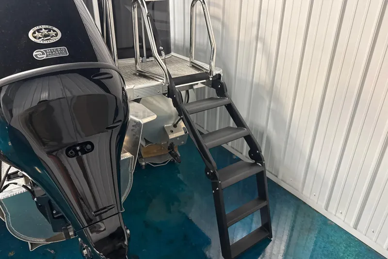 Slide: The Image of 2026 Tahoe Pontoon Sport 85 Rear Fish with motor and boarding ladder in storage. - 9