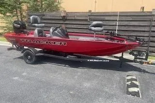 The Image of 2026 Tracker Pro Team 175 boat in red, parked on a trailer outdoors. - 0