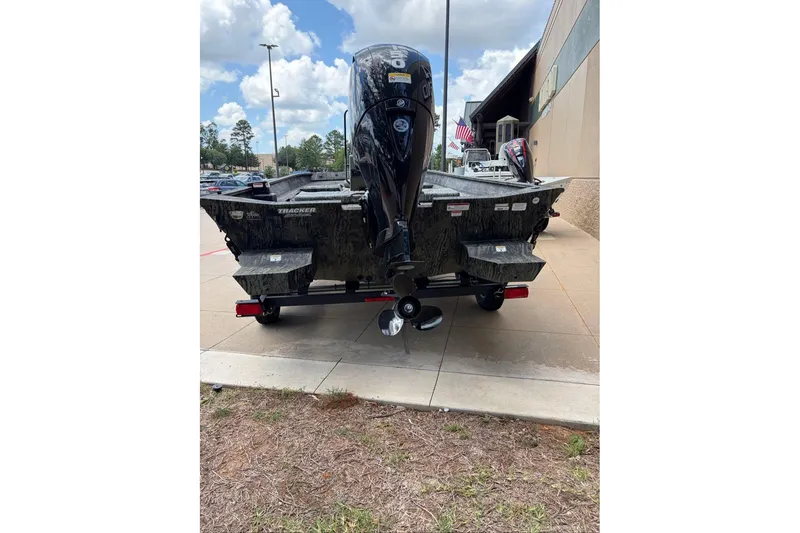 Slide: The Image of 2026 Tracker Grizzly 2072 CC boat with outboard motor, parked outdoors on a sunny day. - 3
