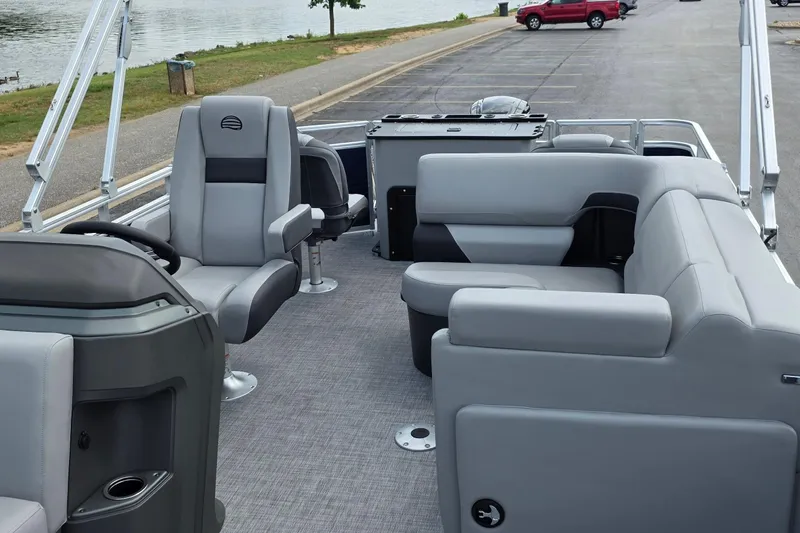 Slide: The Image of 2026 Sun Tracker SportFish 20 DLX pontoon boat interior with gray seating and steering console. - 6
