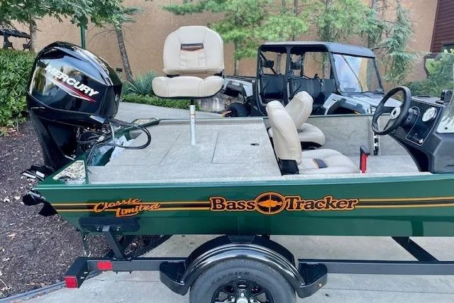 Slide: The Image of 2026 Tracker Bass Tracker Classic Limited boat with Mercury engine, parked outdoors. - 3