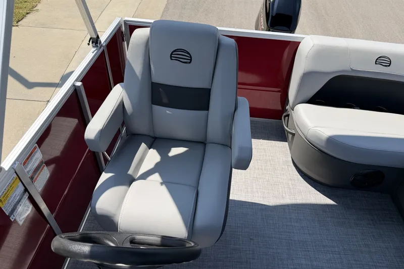 Slide: The Image of 2026 Sun Tracker Party Barge 16 DLX interior with gray seating and steering wheel. - 14