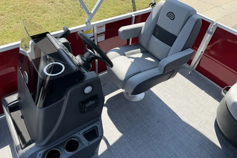 Slide: The Image of 2026 Sun Tracker Party Barge 16 DLX interior with captain's chair and control console. - 12