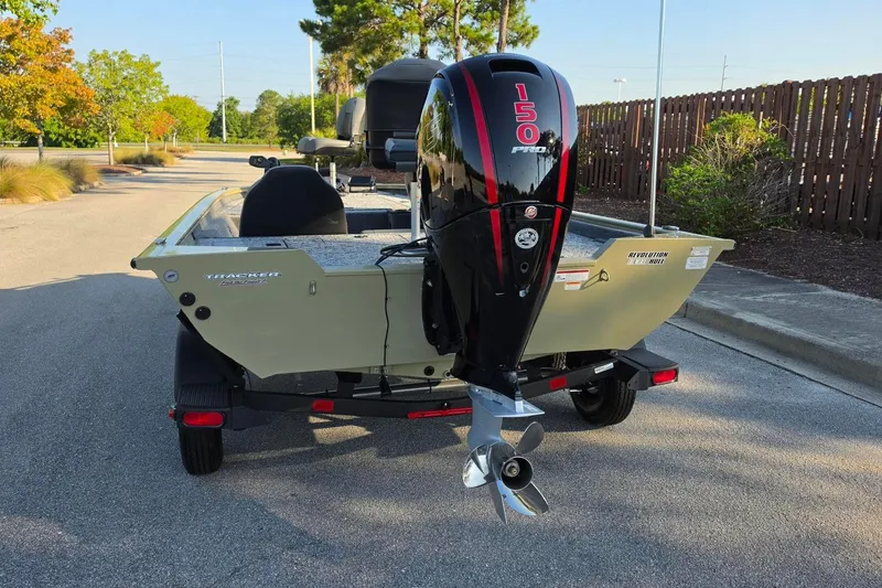 Slide: The Image of 2026 Tracker Pro Team 195 boat with powerful 150 Pro XS engine, parked outdoors. - 11