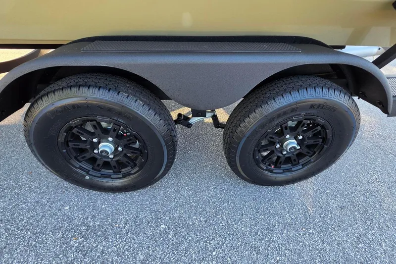 Slide: The Image of Trailer wheels of a 2026 Tracker Pro Team 195 on asphalt surface. - 17