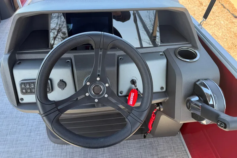 Slide: The Image of 2026 Sun Tracker Party Barge 20 DLX steering console with modern controls and cup holder. - 1