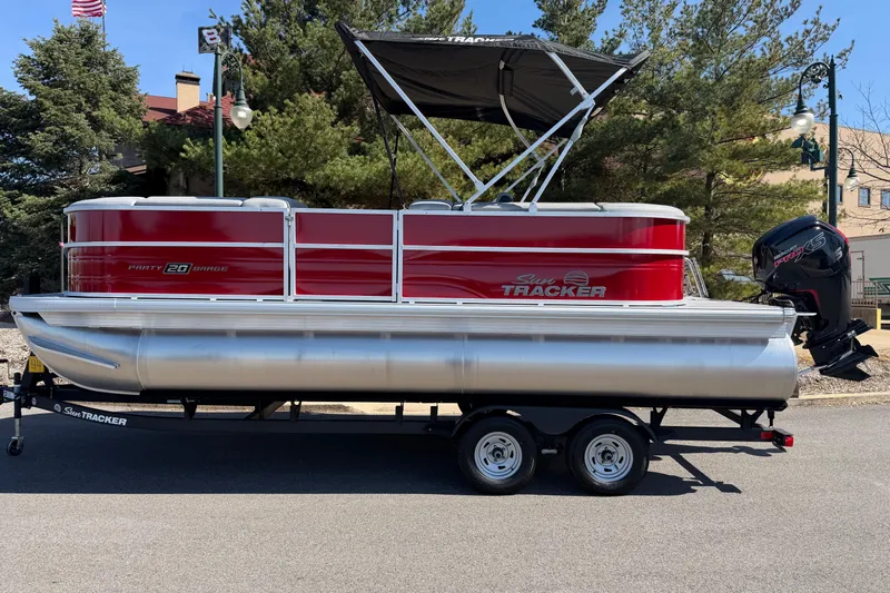Slide: The Image of 2026 Sun Tracker Party Barge 20 DLX pontoon boat on trailer, parked outdoors. - 5