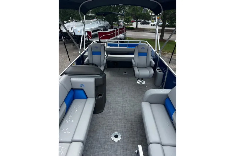 Slide: The Image of 2026 Sun Tracker Party Barge 22 RF DLX interior with gray and blue seating, spacious layout. - 1