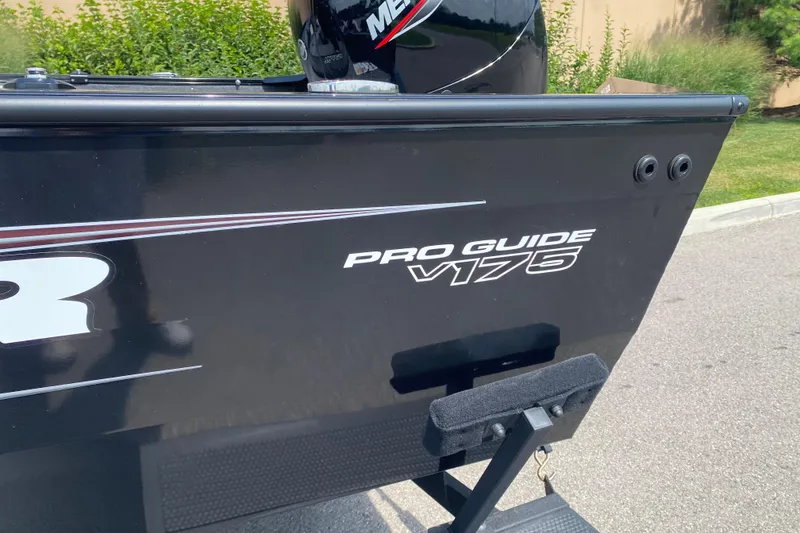 Slide: The Image of 2026 Tracker Pro Guide V-175 Combo boat, black exterior, parked outdoors. - 2