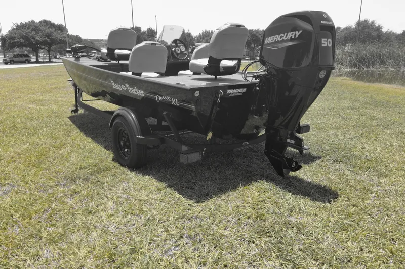 Slide: The Image of 2026 Tracker Bass Tracker Classic XL boat with Mercury 50 engine on grassy field. - 3