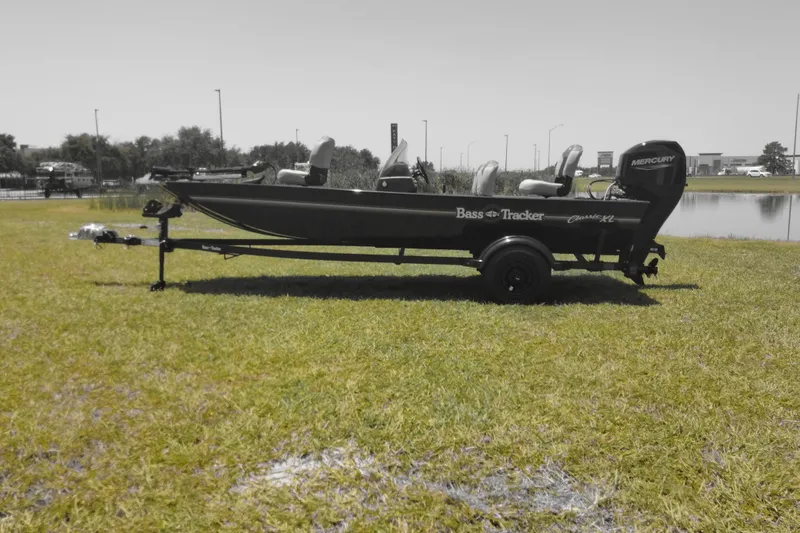 Slide: The Image of 2026 Tracker Bass Tracker Classic XL boat on grassy field near water. - 8