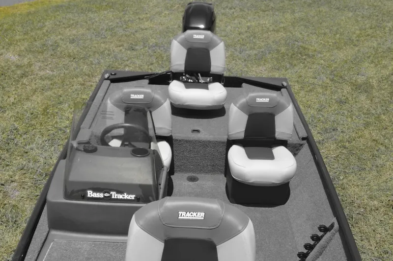 Slide: The Image of 2026 Tracker Bass Tracker Classic XL boat interior with seating and steering wheel on grass. - 11