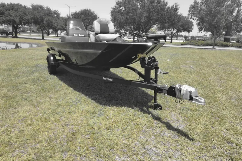 Slide: The Image of 2026 Tracker Bass Tracker Classic XL boat on grassy field, ready for transport. - 2