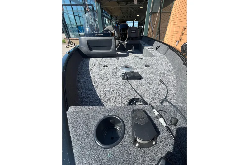 Slide: The Image of 2026 Tracker Pro Guide V-16 SC boat interior with carpeted deck and console view. - 3