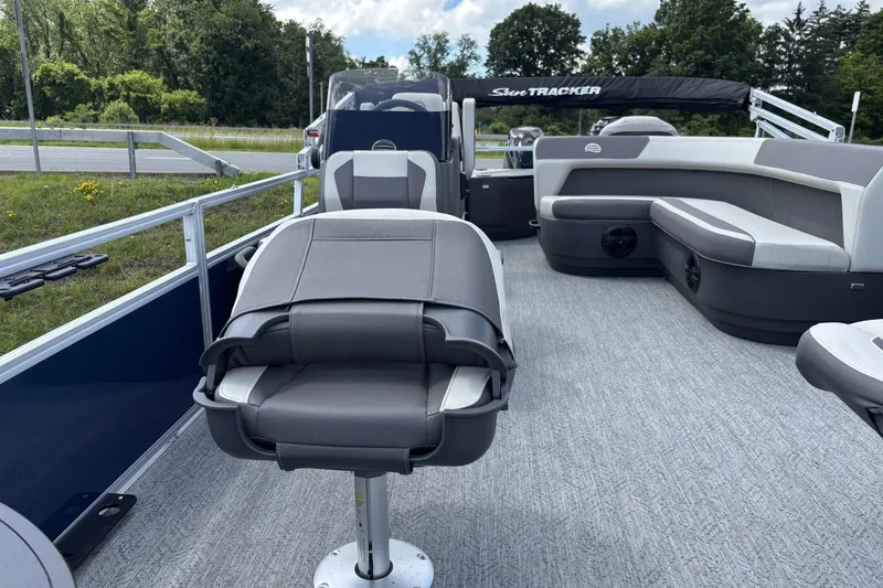 Slide: The Image of 2026 Sun Tracker Bass Buggy 18 DLX pontoon boat interior with seating and helm. - 2