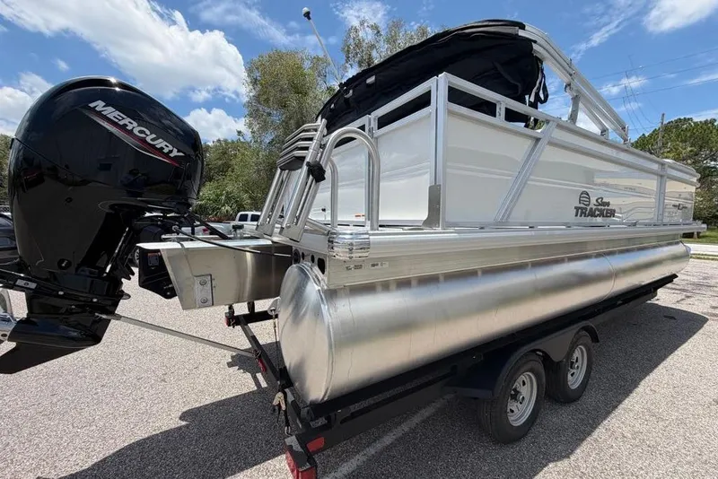 Slide: The Image of 2026 Sun Tracker Party Barge 22 RF DLX pontoon boat with Mercury engine on trailer. - 1