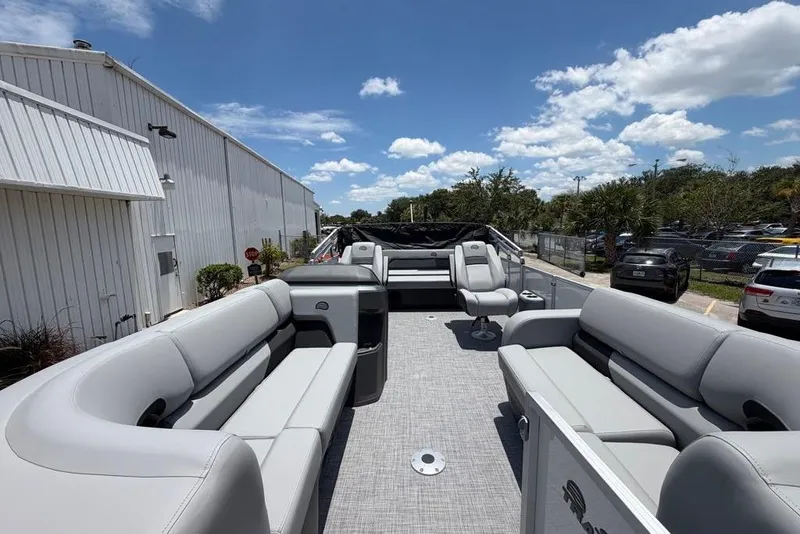 Slide: The Image of 2026 Sun Tracker Party Barge 22 RF DLX pontoon boat with spacious seating under a clear blue sky. - 3