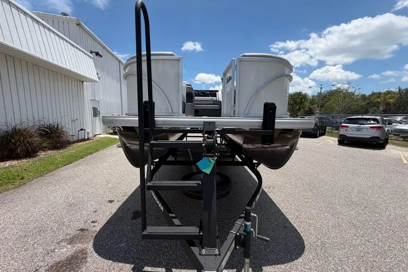 Slide: The Image of 2026 Sun Tracker Party Barge 22 RF DLX pontoon boat on trailer, parked outdoors. - 4