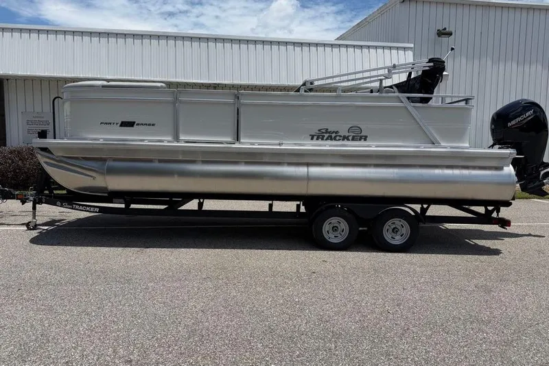 Slide: The Image of 2026 Sun Tracker Party Barge 22 RF DLX pontoon boat on trailer, parked outdoors. - 89