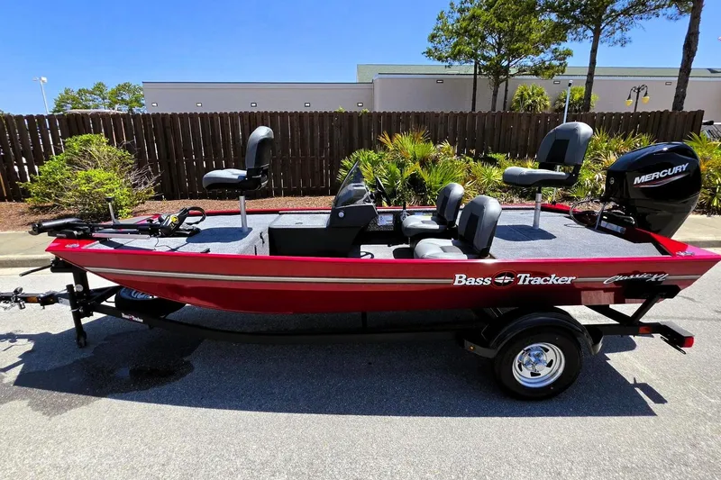Slide: The Image of 2026 Tracker Bass Tracker Classic XL boat with Mercury engine, parked outdoors. - 10
