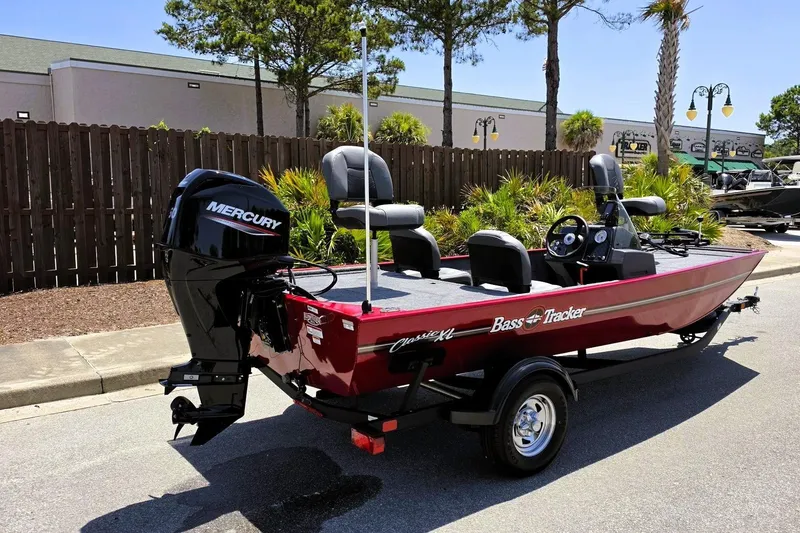 Slide: The Image of 2026 Tracker Bass Tracker Classic XL boat with Mercury engine, parked outdoors. - 2