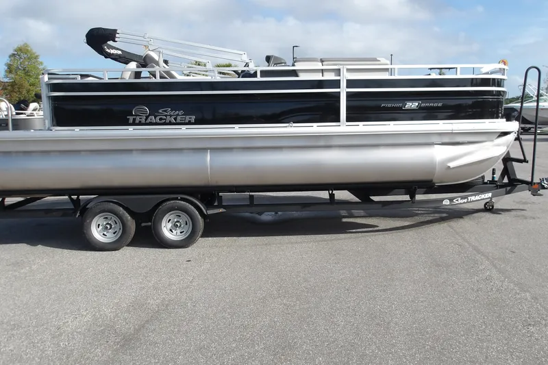 The Image of 2026 Sun Tracker Fishin' Barge 22 DLX pontoon boat on trailer, side view. - 1