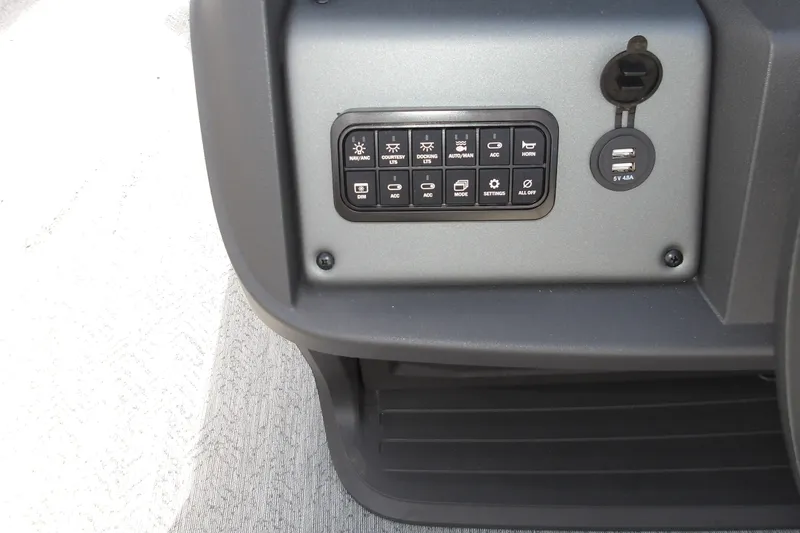 Slide: The Image of Control panel of 2026 Sun Tracker Fishin' Barge 22 DLX with USB port and switches. - 16