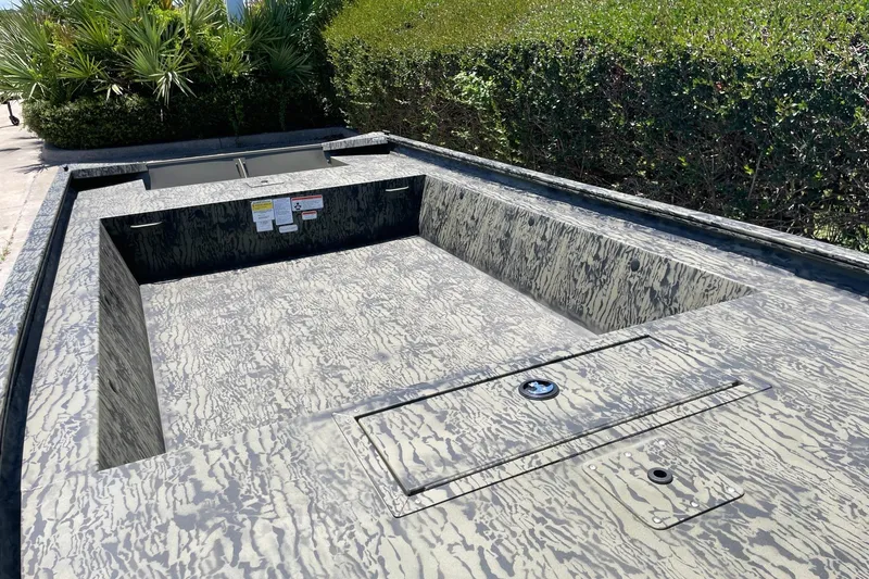 Slide: The Image of 2026 Tracker Grizzly 1754 Utility boat with camouflage interior, surrounded by greenery. - 8