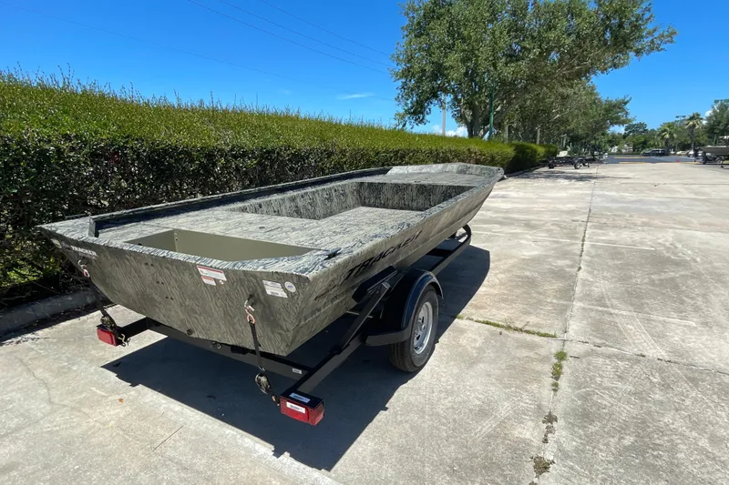 Slide: The Image of 2026 Tracker Grizzly 1754 Utility boat on trailer, parked outdoors on sunny day. - 3