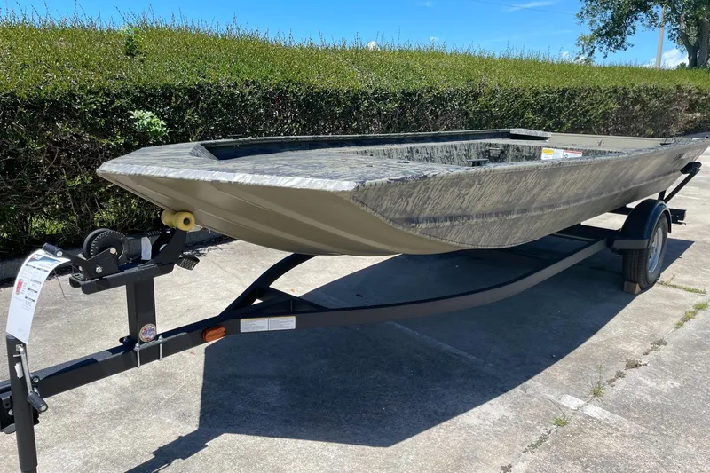 Slide: The Image of 2026 Tracker Grizzly 1754 Utility boat on trailer, parked outdoors on concrete. - 5