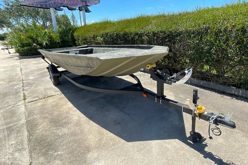 Slide: The Image of 2026 Tracker Grizzly 1754 Utility boat on trailer, parked outdoors on a sunny day. - 2