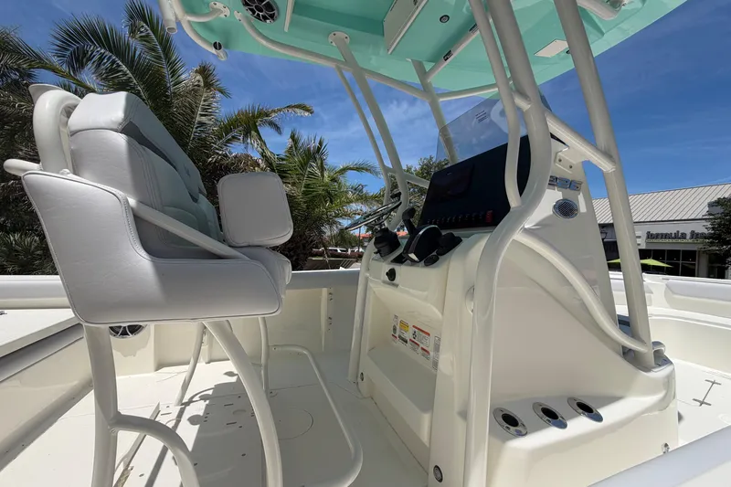 Slide: The Image of 2026 Mako 226 Center Console boat interior with helm and seating, under a clear blue sky. - 7