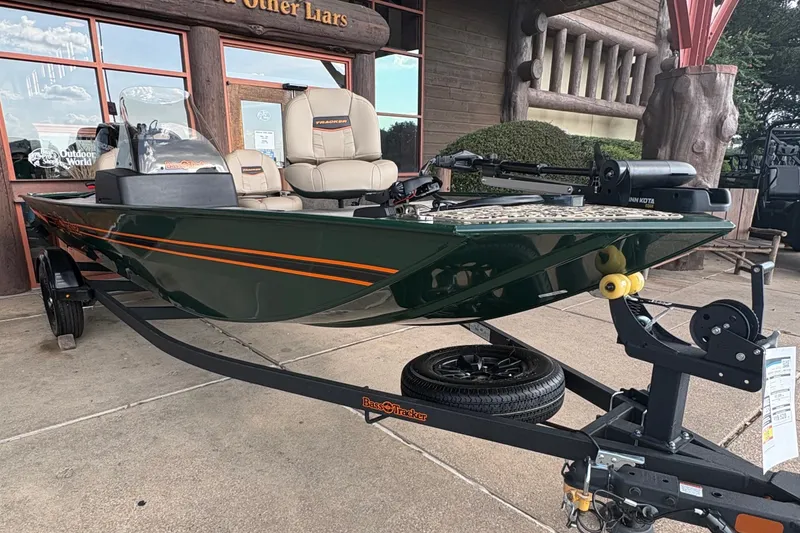 Slide: The Image of A 2026 Tracker Bass Tracker Classic Limited boat on a trailer in front of a wooden building. - 4