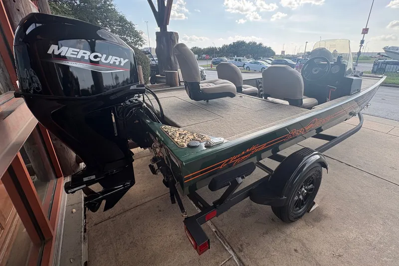 Slide: The Image of A 2026 Tracker Bass Tracker Classic Limited boat with a Mercury outboard motor, parked on a trailer. - 6
