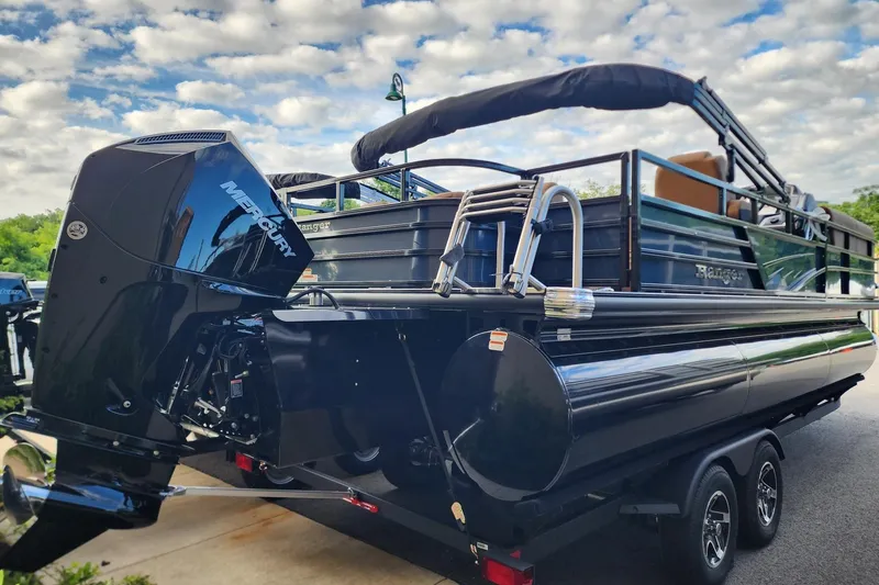 Slide: The Image of 2026 Ranger 223FC pontoon boat with Mercury outboard motor, parked under a cloudy sky. - 5