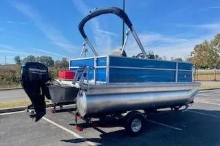 Slide: The Image of 2026 Sun Tracker Party Barge 16 DLX pontoon boat on trailer in parking lot. - 3