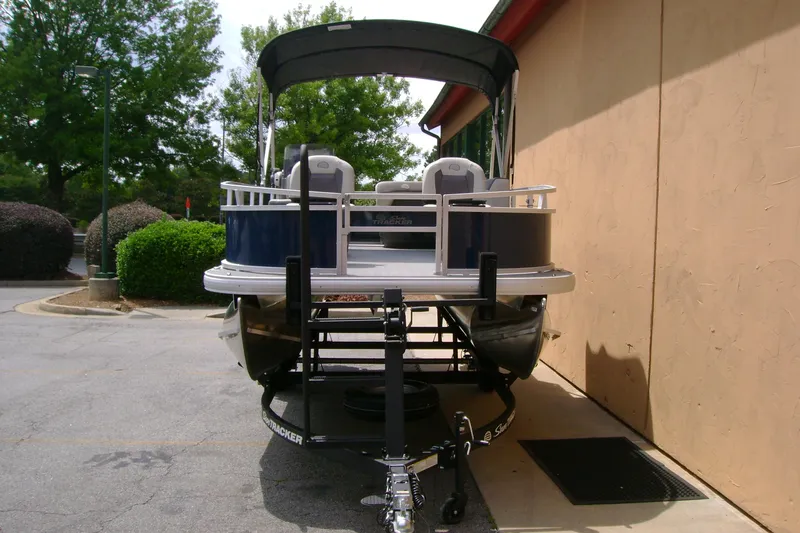Slide: The Image of 2026 Sun Tracker Bass Buggy 16 XL Select pontoon boat parked outdoors. - 3
