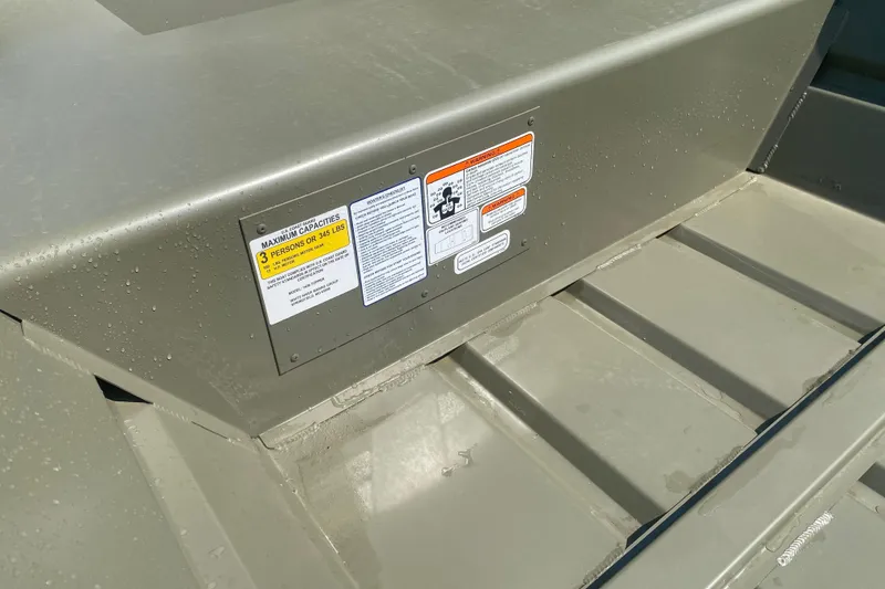 Slide: The Image of 2026 Tracker Grizzly 14 Jon boat interior with capacity warning labels. - 3