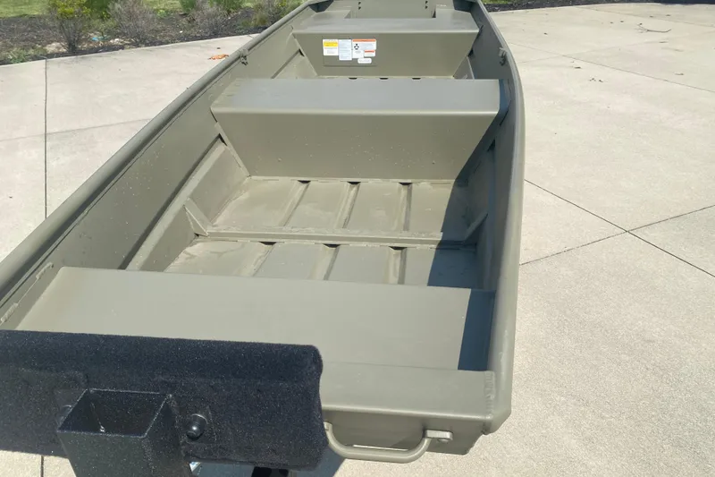Slide: The Image of 2026 Tracker Grizzly 14 Jon boat on concrete surface, showcasing interior seating and design. - 2