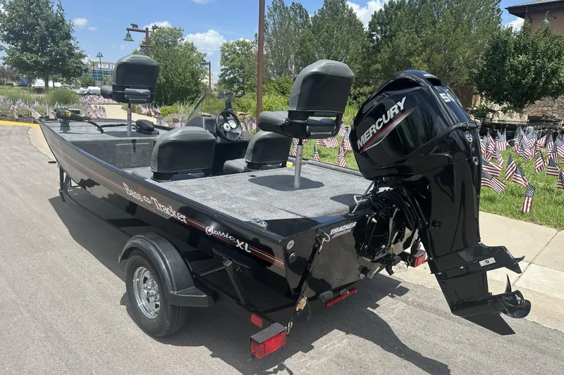 Slide: The Image of 2026 Tracker Bass Tracker Classic XL boat with Mercury engine, parked outdoors. - 2
