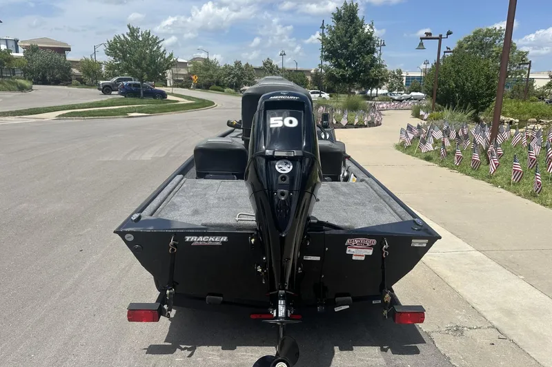Slide: The Image of 2026 Tracker Bass Tracker Classic XL boat on trailer, parked on street with American flags. - 3
